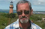 A man standing in front of a lighthouse.